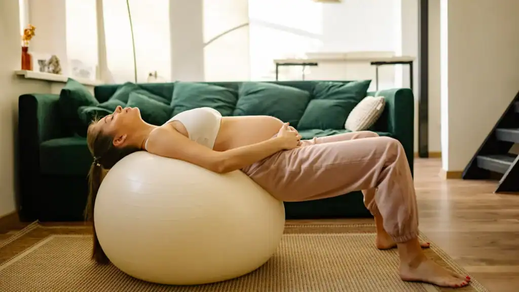 How to Support Your Body During Pregnancy for Faster Postnatal Recovery 1 Pregnant woman resting on exercise ball.